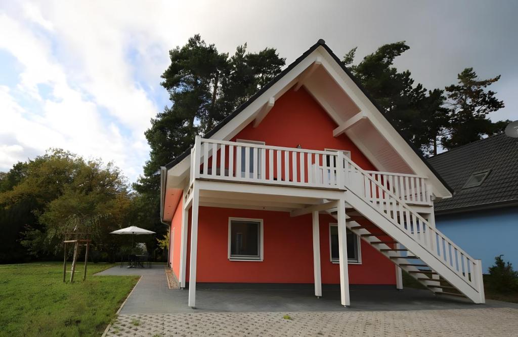 a red house with a white staircase on it at Roter Blitz 2 k108 in Röbel