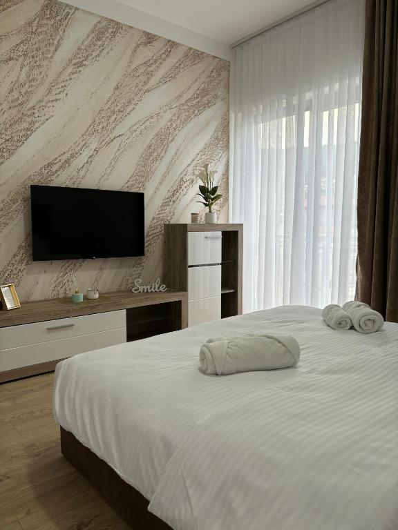 a bedroom with a bed with a flat screen tv at Prenoćište Lovac in Prijepolje