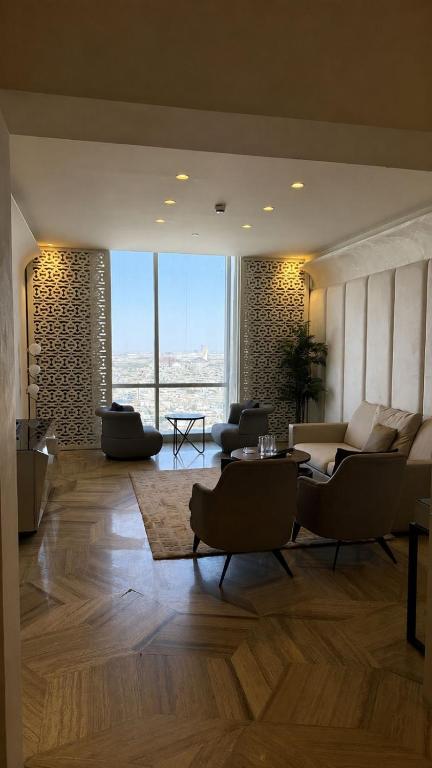 a living room with couches and a large window at برج داماك الرياض in Riyadh