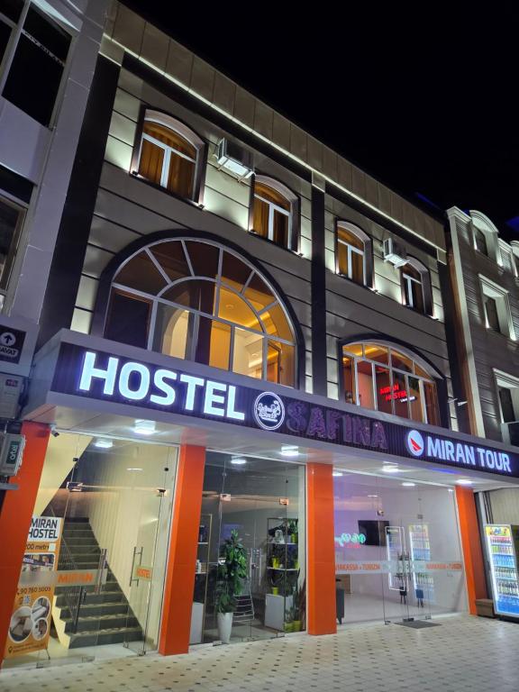 a hotel with a sign on the front of it at Miran Hostel 2 Vokzal in Andizhan