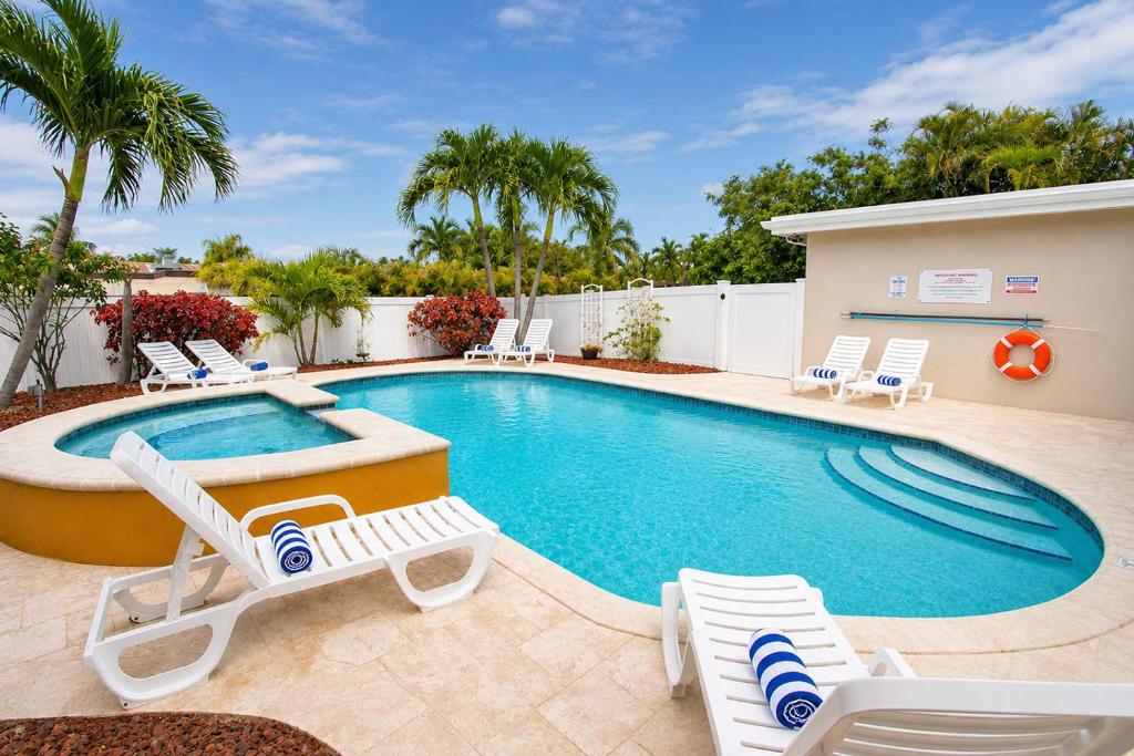 a swimming pool with lounge chairs and a pool at Premium Luxury 5BR Villa near Hollywood Beach in Hollywood