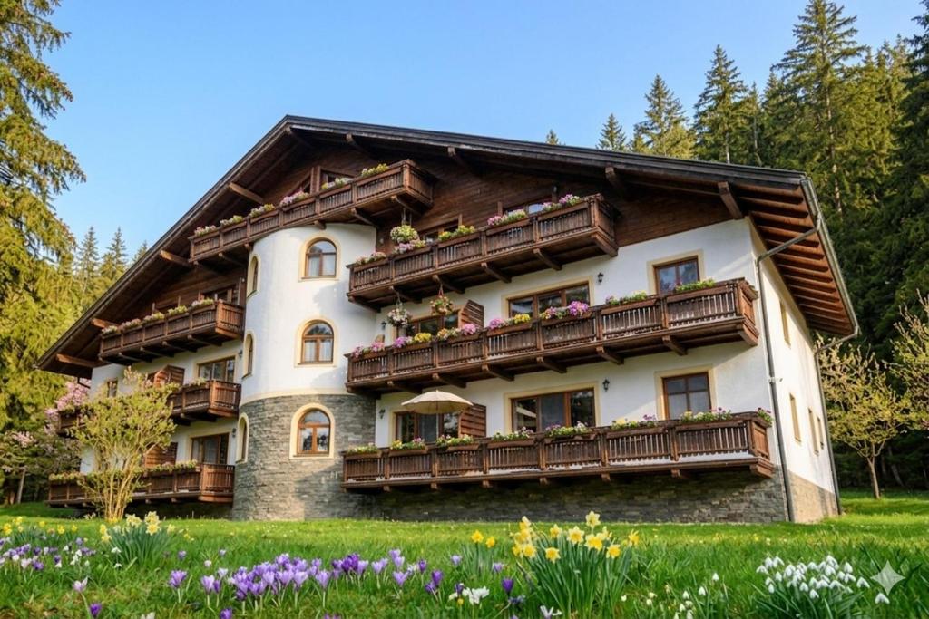 a house with balconies and flowers in front of it at Apartmán Emy in Bystrá