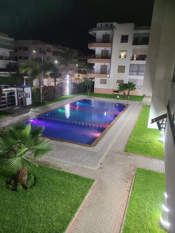 a swimming pool at night in front of a building at Maison Confortable in Pont Blondin