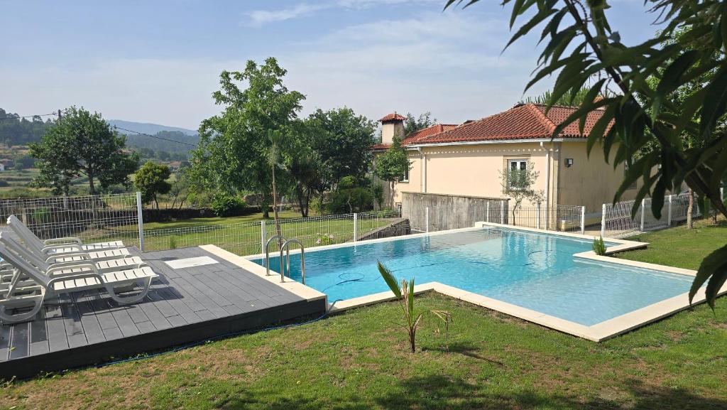 a swimming pool in a yard next to a house at Fernandes House in Paredes de Coura