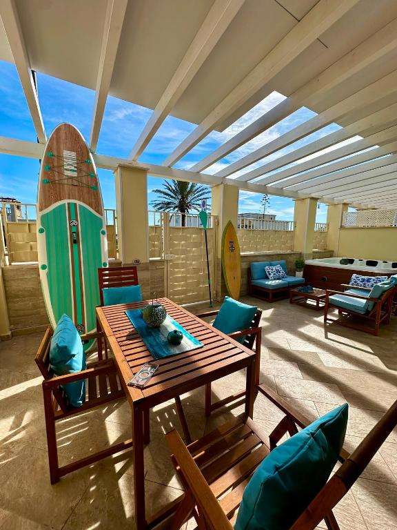 a living room with a table and a surfboard at Blu Suite Ostia in Lido di Ostia