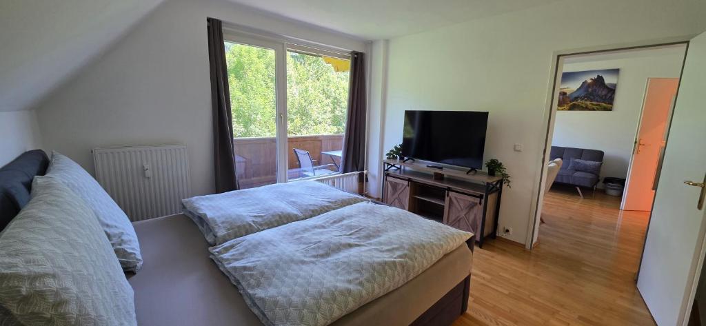 a bedroom with a bed and a tv and a window at Zimnitzblick in Haiden