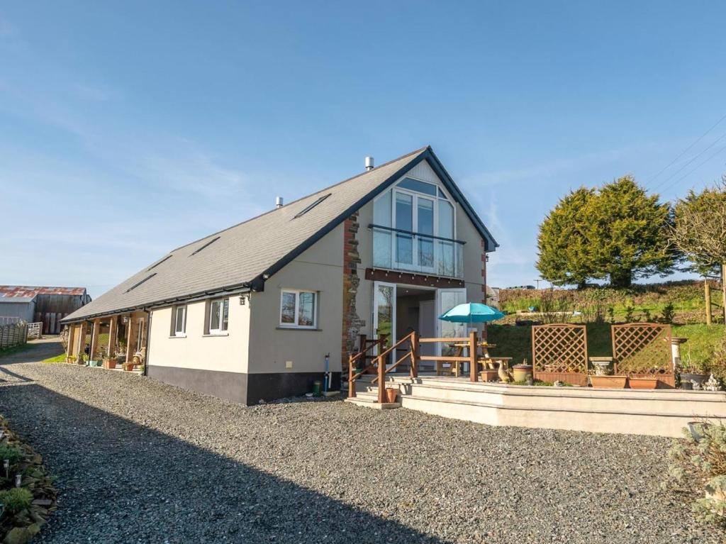 a house on a gravel road with a building at 4 Bed in Holsworthy oc-77663 in Milton Damerel
