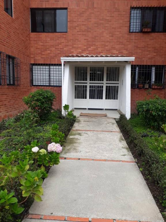 a brick building with a garage and a walkway at Vilma's BnB in Mérida