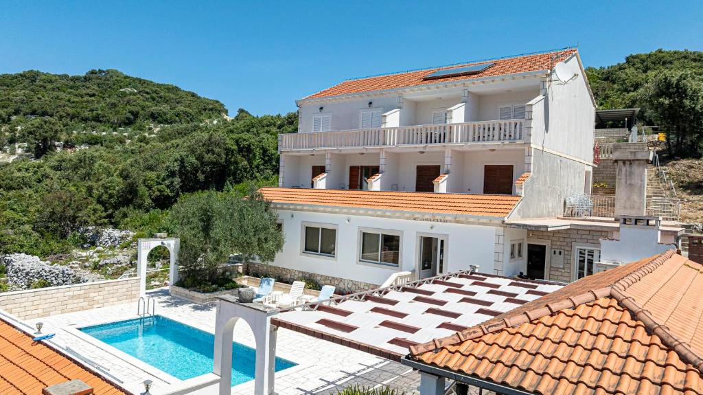 a large white house with a swimming pool at Villa Castello in Korčula