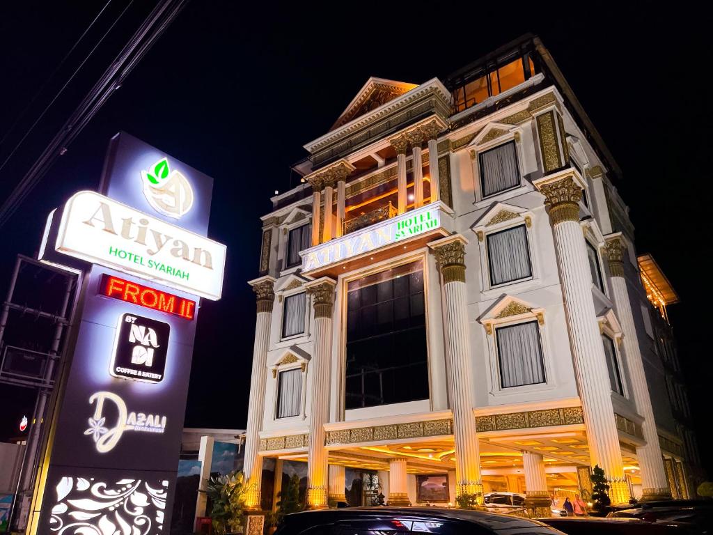 a building with neon signs in front of it at Atiyan Hotel Syariah in Bukittinggi