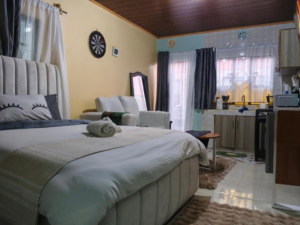 a bedroom with a large bed and a kitchen at New Era Homes in Kimana