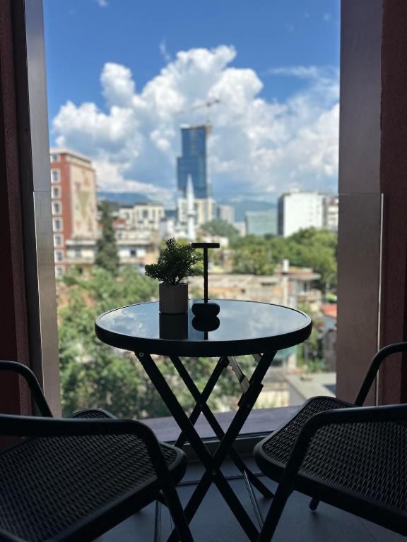 a small table on a balcony with a view of a city at Foel Apartament in Tirana