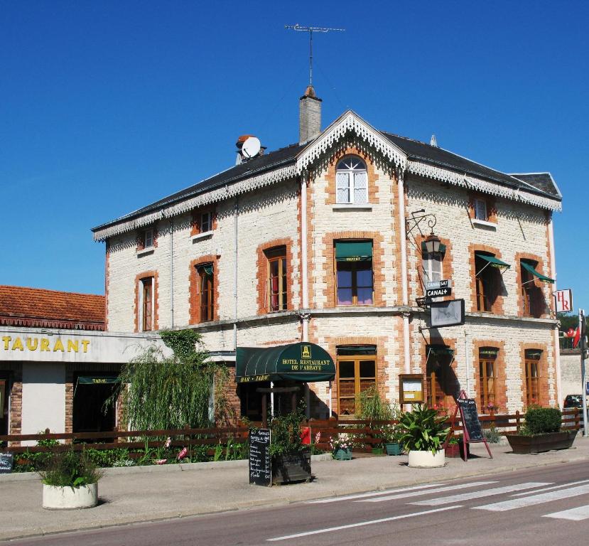 an old brick building on the corner of a street at Hôtel Restaurant de l'Abbaye in Clairvaux