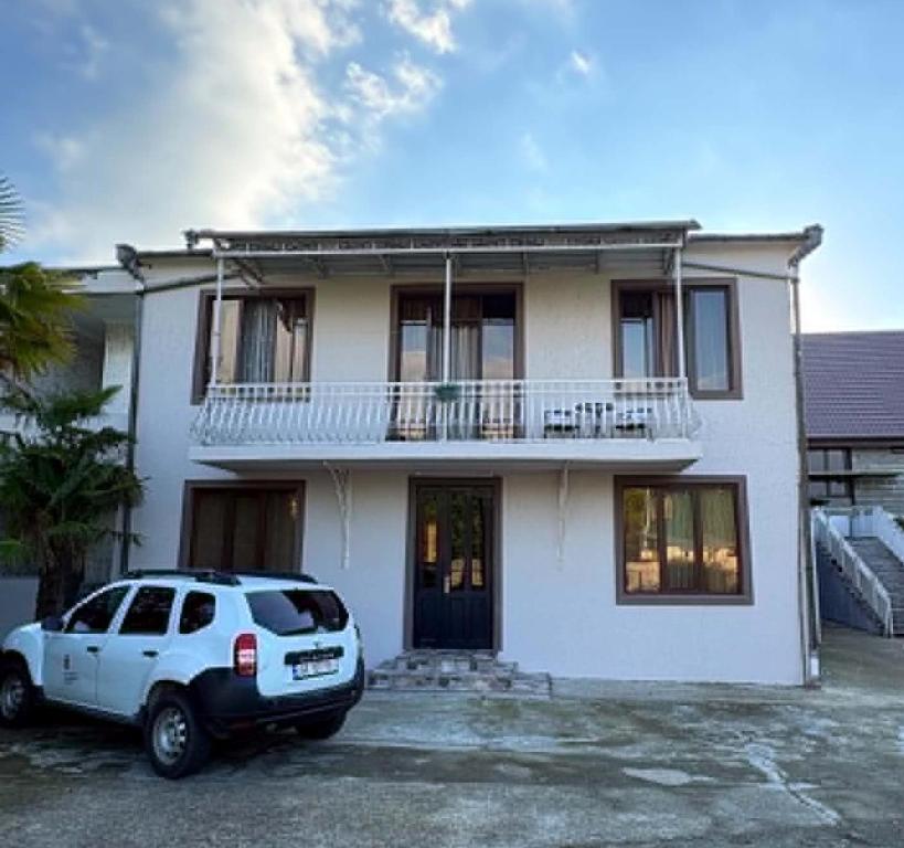 a white house with a car parked in front of it at Lukas's house in Kobuleti
