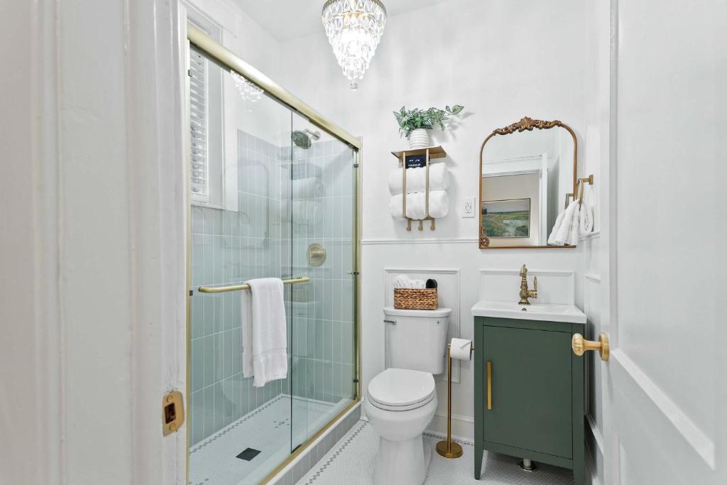 a bathroom with a toilet and a glass shower at Darling Downtown Renovated Historic Condo Walkable in Savannah