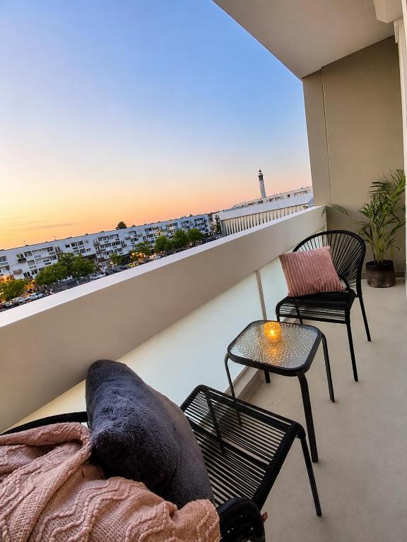 a balcony with a couch and two chairs and a table at La parenthèse in Calais