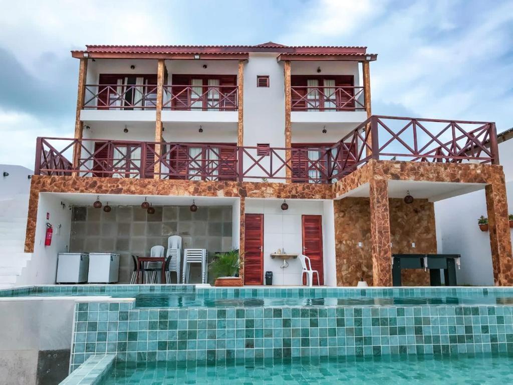 a villa with a swimming pool in front of a house at Villa do Sol - Icaraí de Amontada in Icaraí