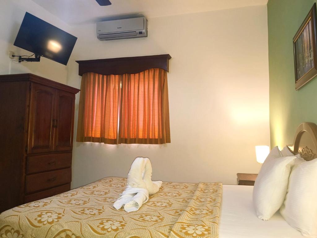 a hotel room with a bed with a towel animal on it at Hotel La Morada in Santo Domingo