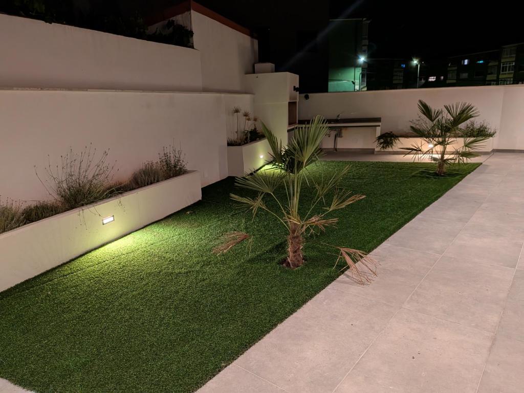 a garden with artificial grass and lights in a building at Jardín del Jiloca in Calamocha