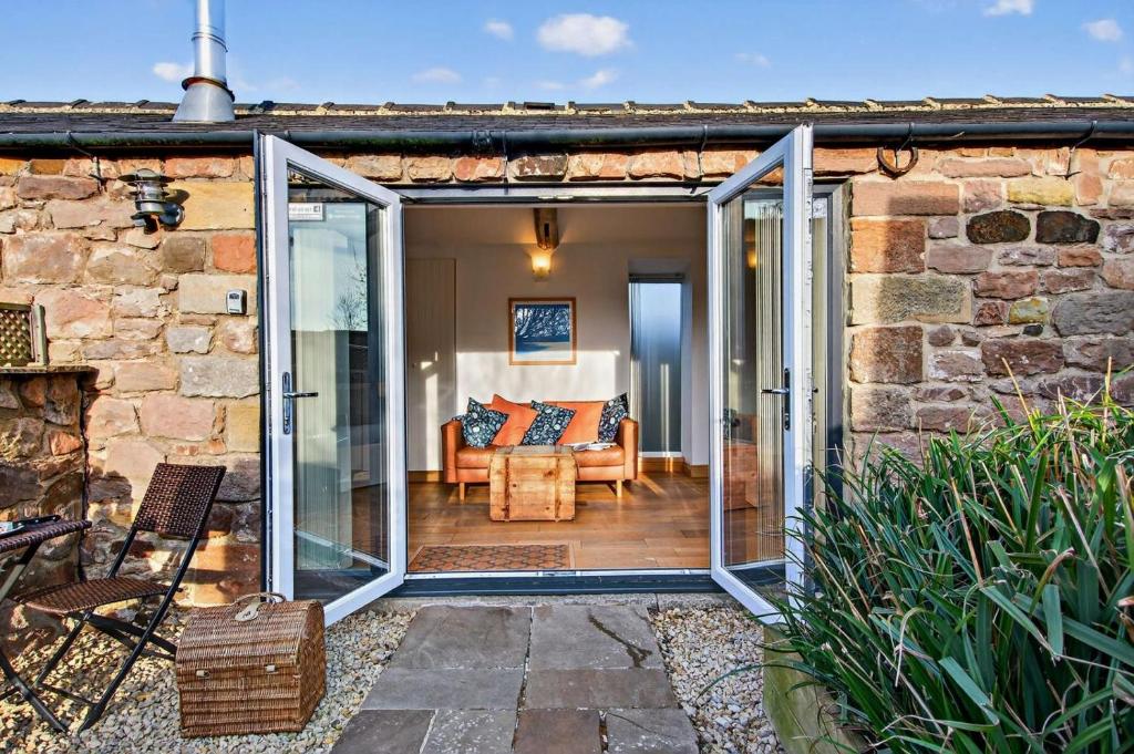 an open sliding glass door of a stone house at 1 Bed in Belford oc-cn002 in Lucker