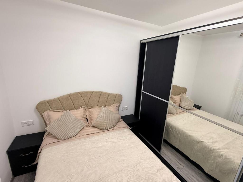 a small bedroom with a bed and a mirror at Miry Apartment in Târgu Neamț