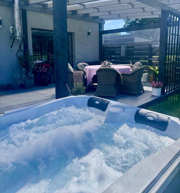 a bath tub filled with snow in a yard at Domek z jacuzzi Studnica 39 in Studnica