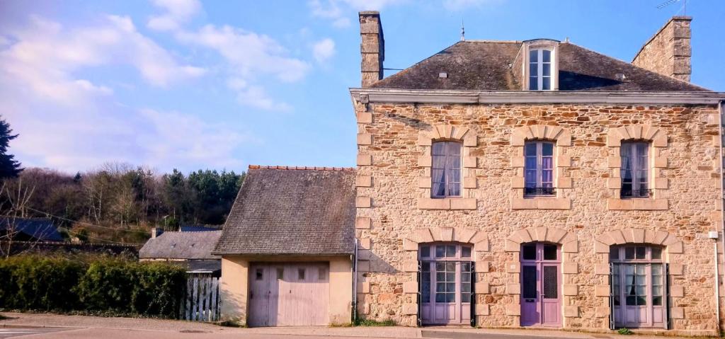 an old stone building with a chimney on top at Maison le 28 in Jugon Les Lacs