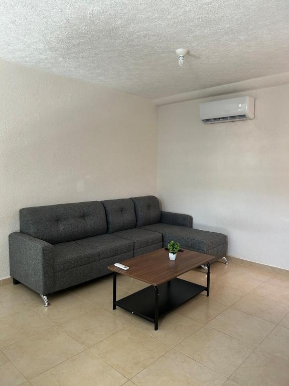 a living room with a couch and a coffee table at Comfortable apartment with pool near beaches in Acapulco
