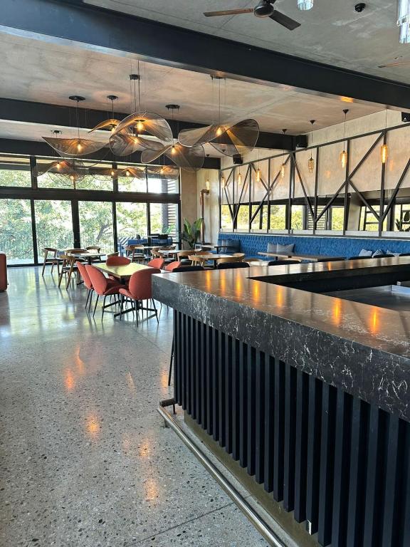 a restaurant with a bar with tables and chairs at Midrand Stylish 1Bedroom Escape in Midrand