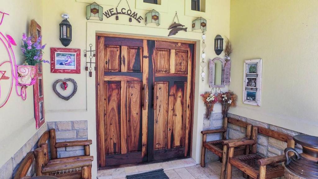 - une grande porte en bois dans une chambre avec bancs dans l'établissement Sweet Dreams Guest House, à Melkbosstrand