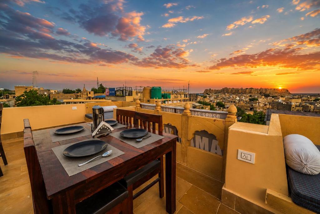 a table on a balcony with a view of a city at Hotel Saffron Diamond in Jaisalmer