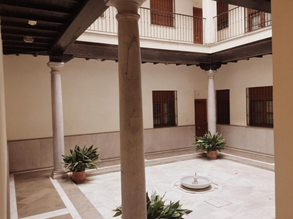 a large room with columns and potted plants at Bonito Apartamento en el centro de Granada con parking gratis in Granada