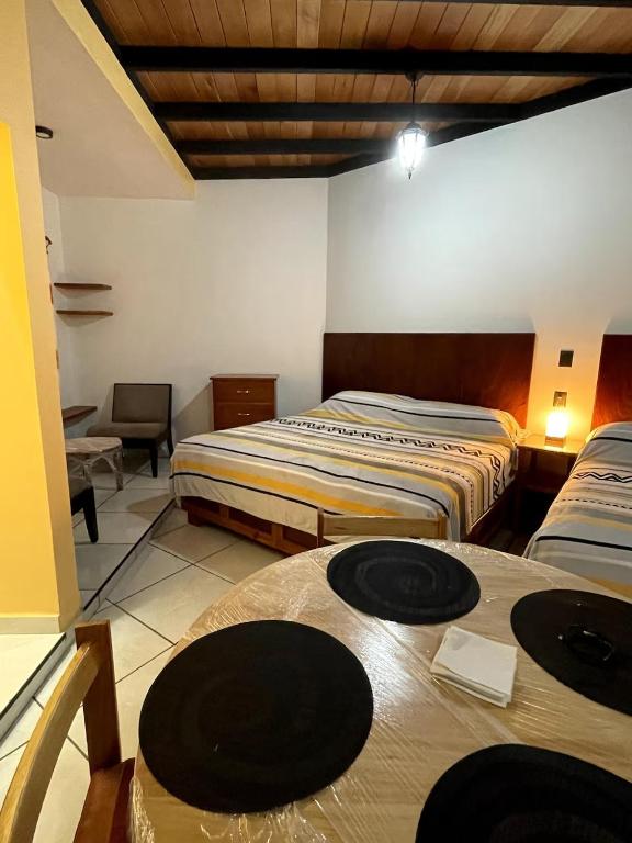 a hotel room with two beds and a table at Casa María Bonita - Loft Bonito in La Cal