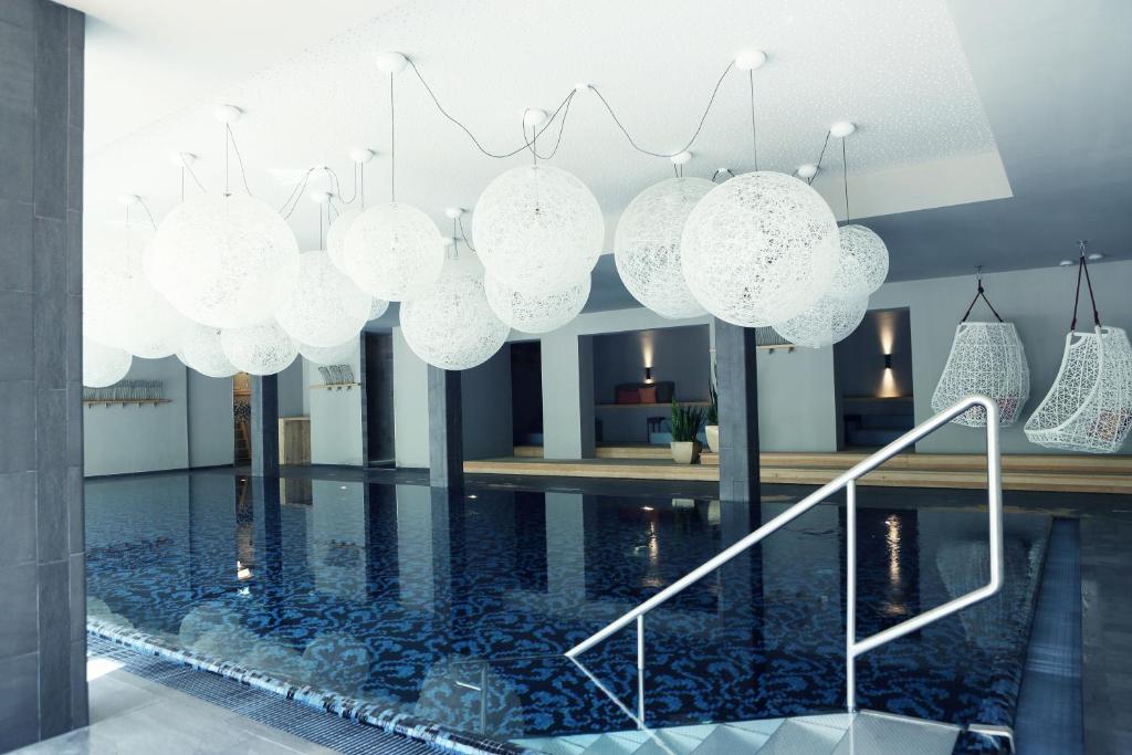 - un groupe de lumières suspendues au-dessus d'une piscine dans l'établissement Walliserhof, à Brand
