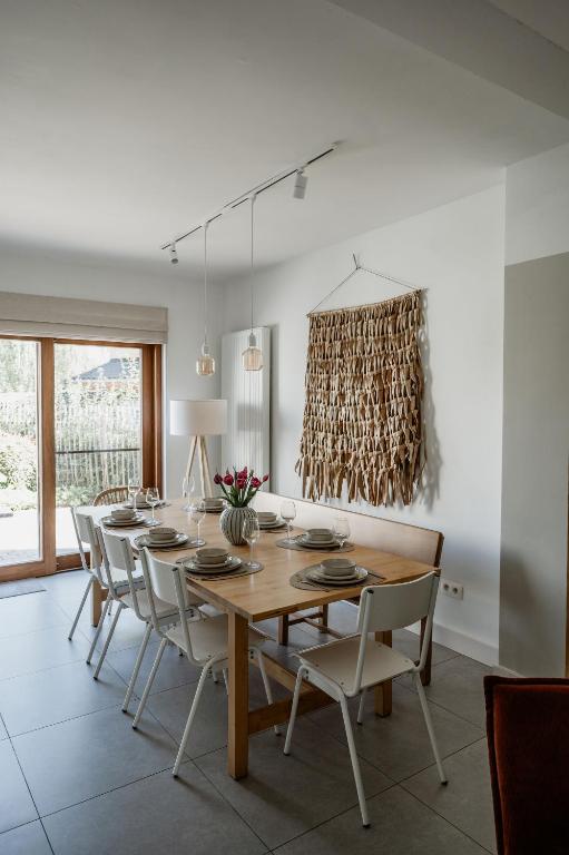 a dining room with a wooden table and chairs at Vakantiewoning Spoor 23 in Borgloon