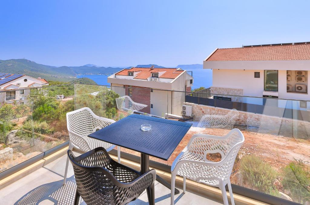 a table and chairs on a balcony with a view at Hemera Suite in Kaş