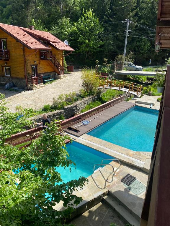 a swimming pool in front of a house at Ребровач in Tatariv