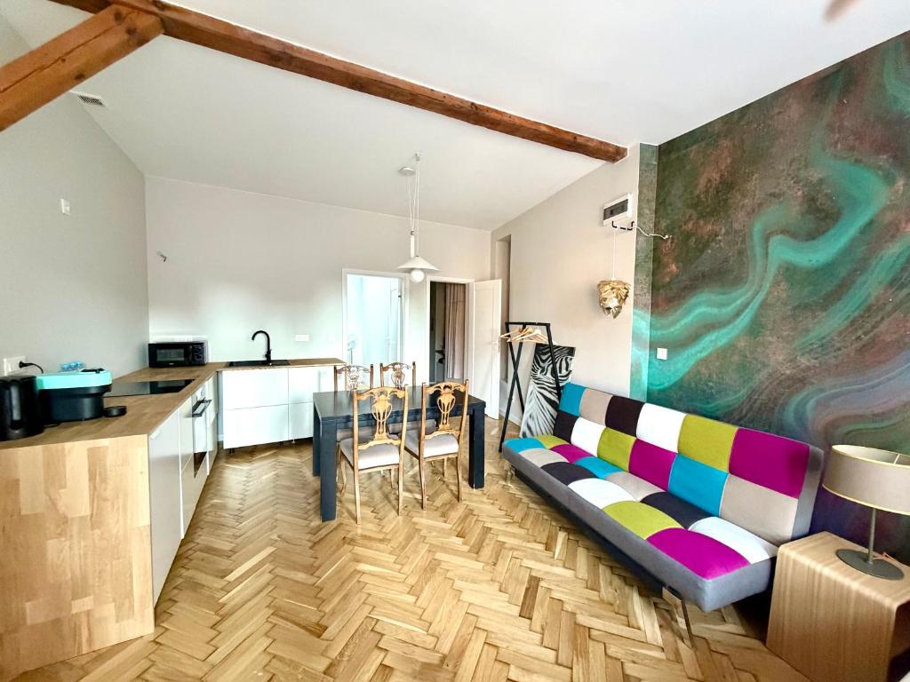 a living room with a couch and a kitchen at Apartamenty Stara Winiarnia in Wałcz