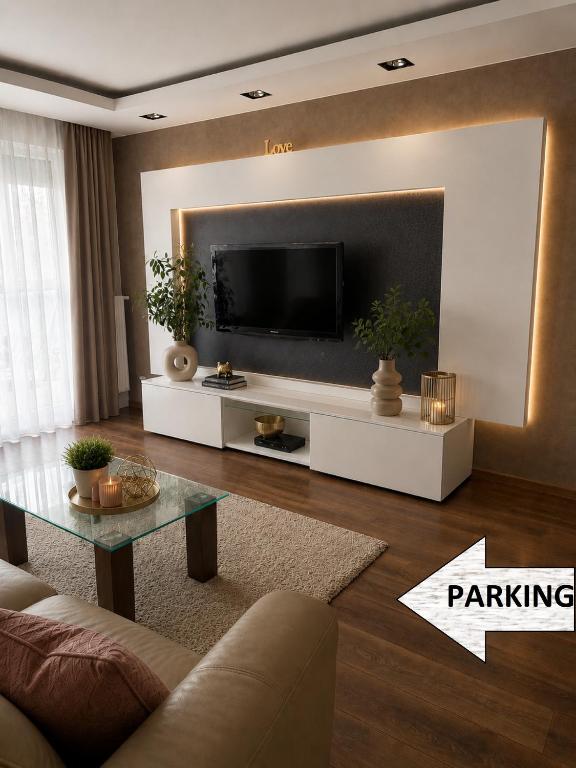 a living room with a flat screen tv on a wall at Vijolie West Exclusive in Warsaw