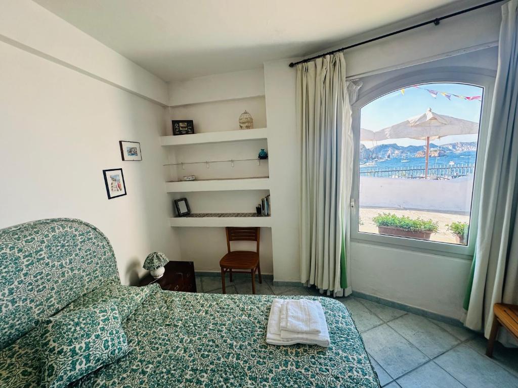 a bedroom with a bed and a window with a view at Salsedine - Immobilevante in Ponza