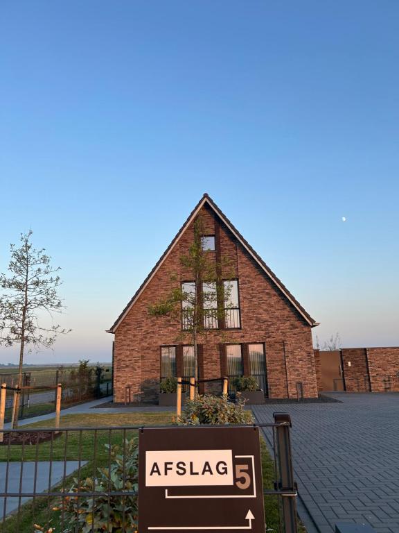 a sign in front of a large brick building at Afslag 5 Texel Bed by Brandenburg in Den Burg