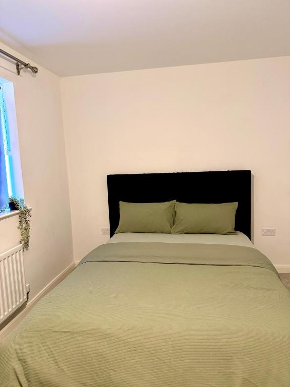 a bedroom with a large bed with a black headboard at Classic Foenix Home in Milton Keynes