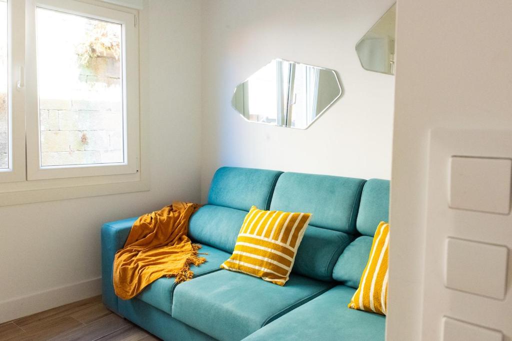 a blue couch with yellow pillows in a room at Villa Martena in Cambados