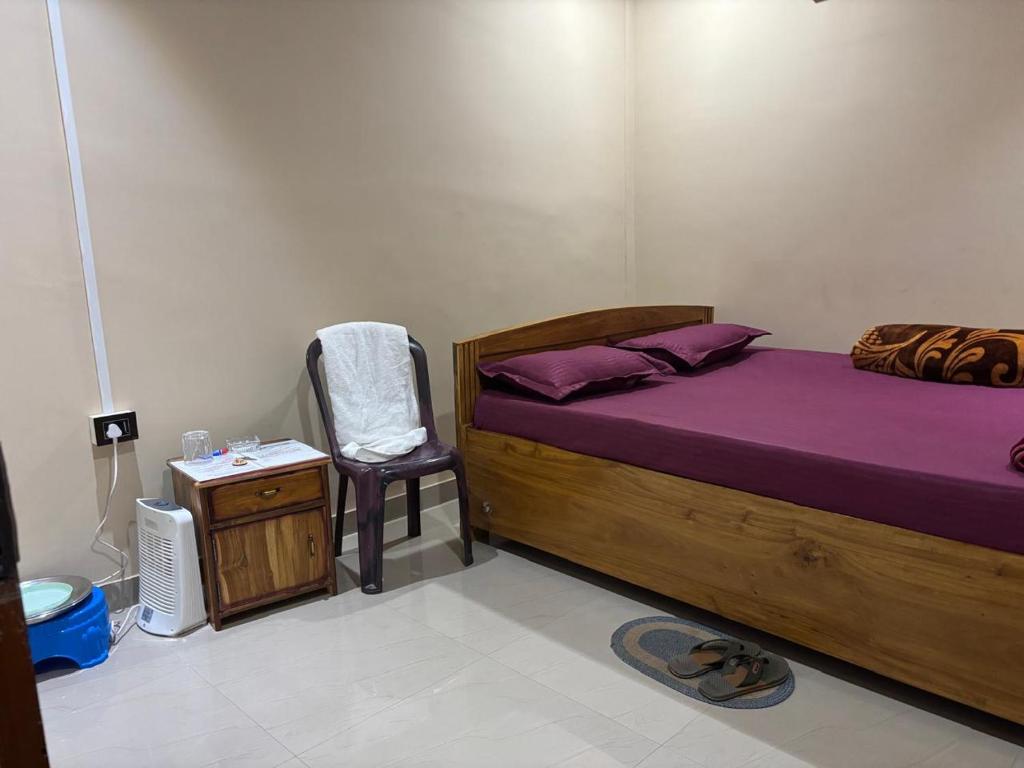 a bedroom with a bed with purple sheets and a chair at RADHE RADHE HOMESTAy in Dithur