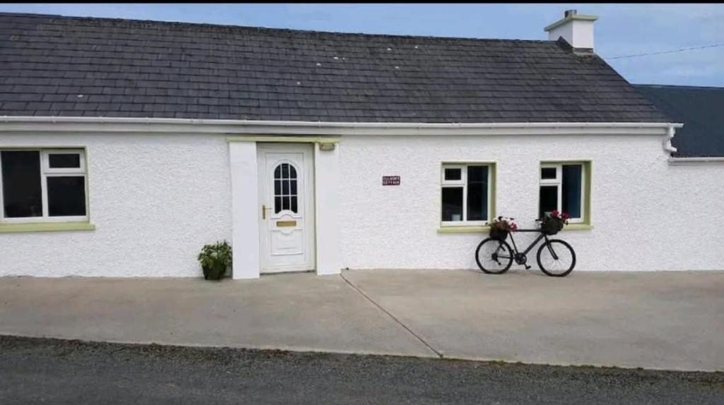 a bike parked in front of a white house at Culoort Cottage - Malin Head in Malin Head