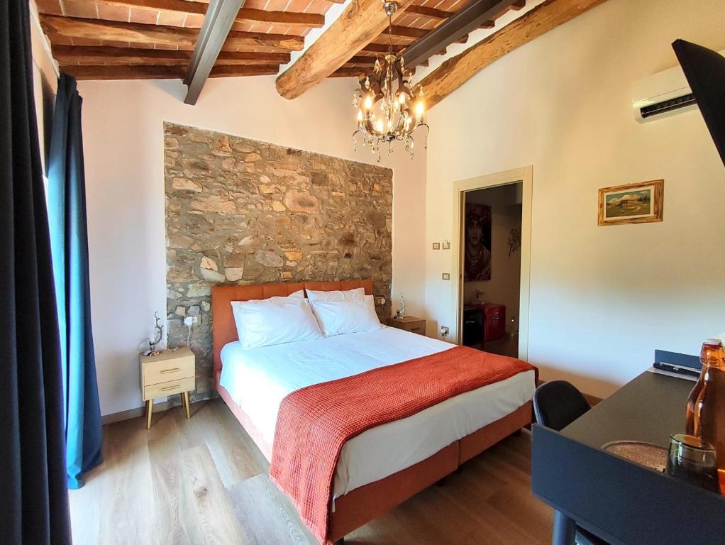 a bedroom with a bed and a stone wall at B&B Toringo in Capannori