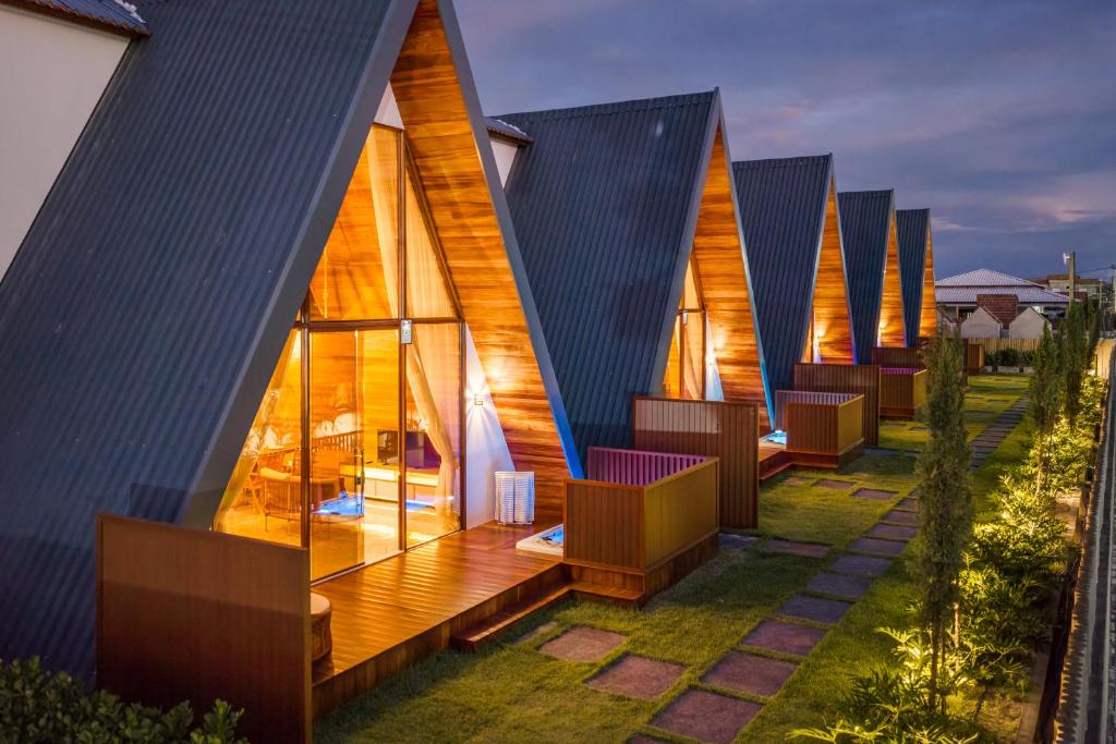a row of lodges with chairs on a lawn at Pousada Recanto dos Chalés in Cruz