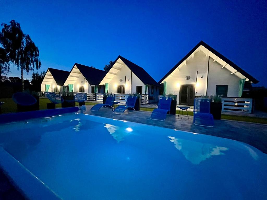 a swimming pool in front of a house at night at Domki Kompas in Jantar