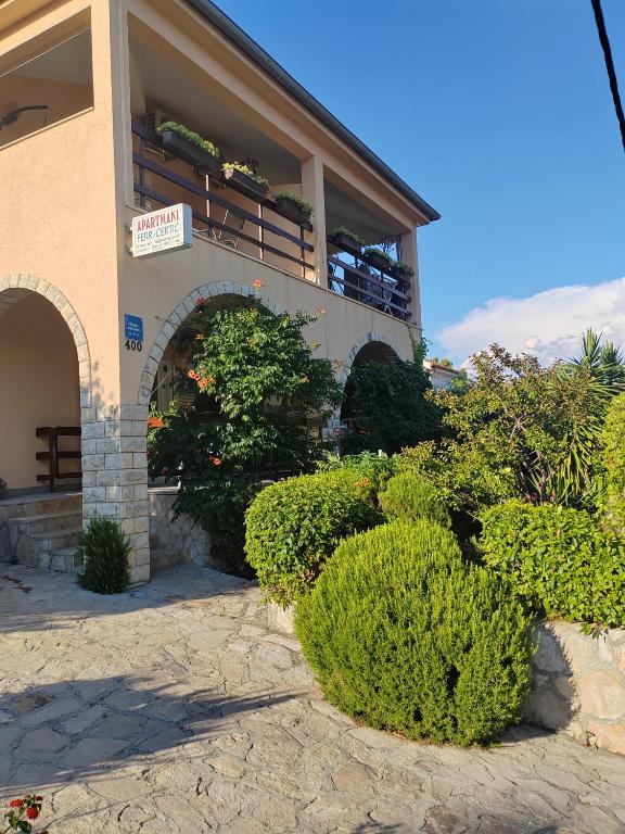 a building with bushes in front of it at Apartmani Ferri 2 in Vrbanj