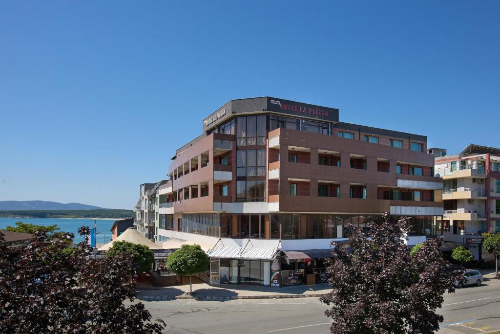 a tall building with a sign on top of it at La Piazza Primorsko Rooms & Apartments in Primorsko